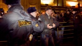 Police detain one of dozens of activists at a protest rally in central Moscow.