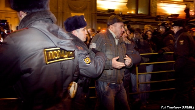 Police detain one of dozens of activists at a protest rally in central Moscow.