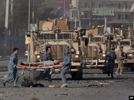 Security forces carry a wounded British man at the site of a suicide attack outside the British Council in Kabul.