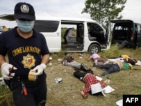 A police investigator gathers evidence at the scene of the massacre in Ampatuan.