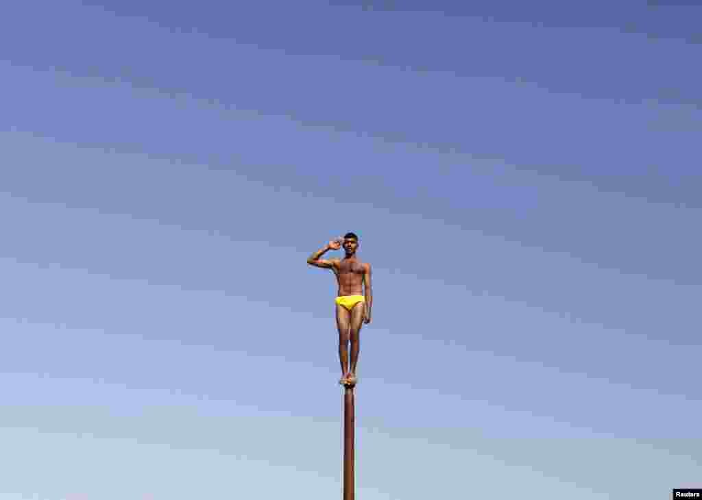 An Indian Army soldier performs "Malkhamb," or traditional Indian gymnastics, during an awareness program to attract youth in joining the armed forces on the eve of India's Republic Day at Gandhinagar, in the western state of Gujarat. (Reuters/Amit Dave)