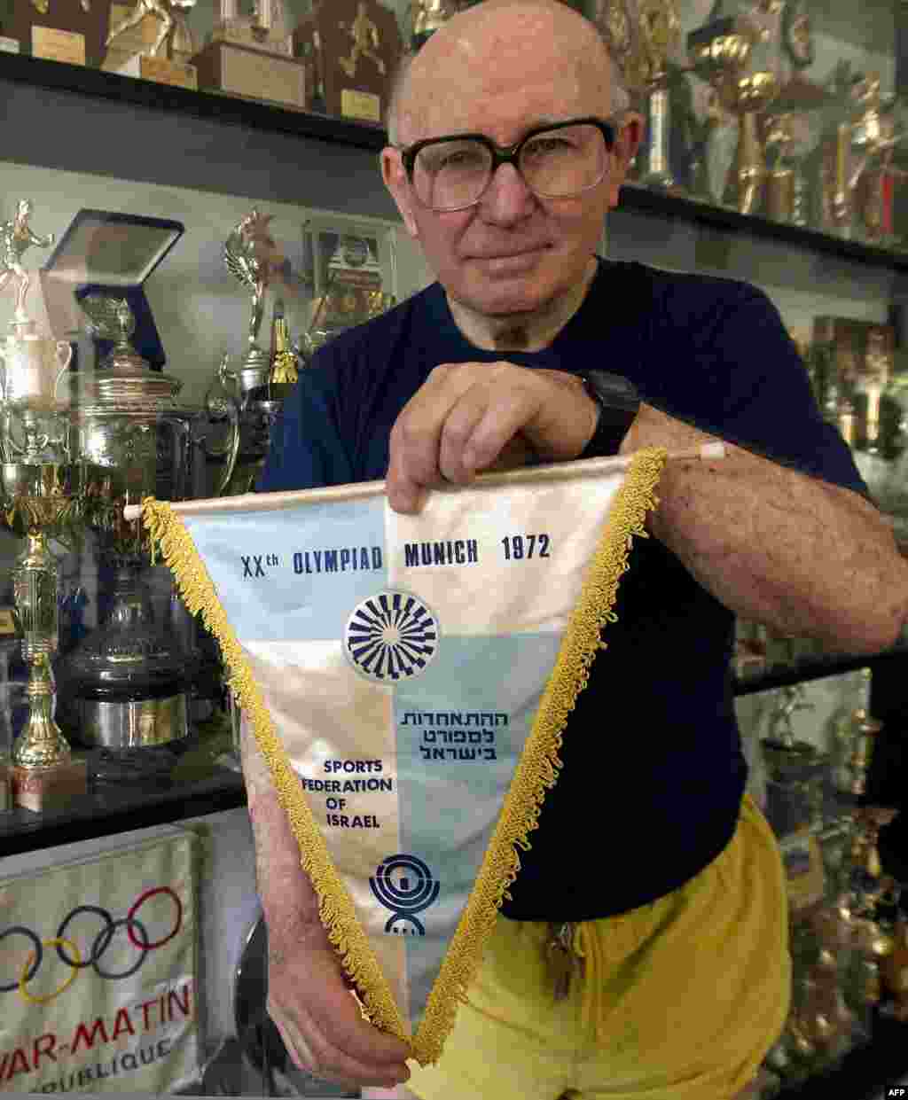 Race walker Shaul Ladany, who escaped a Nazi concentration camp and survived the 1972 Munich ordeal, shows the 1972 Israeli Olympic team's flag at his home in Omer in April 2012.