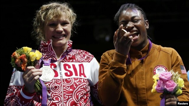 Claressa Shields (right) of the United States poses with her gold medal accompanied by silver medallist Nadezda Torlopova of Russia during the presentation ceremony for the women's middleweight boxing competition at the London Olympic Games on August 9. 