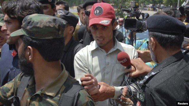 Pakistani police escort one of the two men they said were suspected to be dancing in the footage of a wedding as he leaves after appearing before the Supreme Court in Islamabad on June 6.