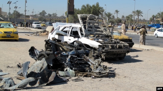 Destroyed vehicles at the site of a car bomb set off by a suicide attacker in the center of Baghdad as part of a wave of deadly attacks across Iraq. 