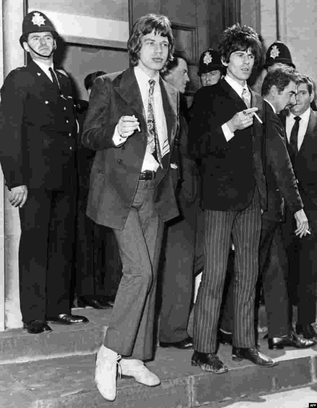 Jagger and Richards leave a court in Chichester, England, after being charged with drugs possession in 1967 following a police raid of Richards' home.