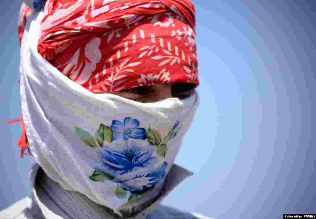 A woman collects potatoes in Jalilabad. She covers her head to protect herself against the sun and insects. During the harvest she will spend all day in the fields. 