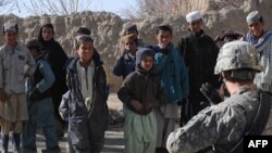 A US soldier talks with Afghan children