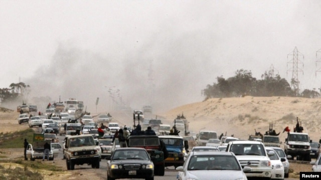 Rebel fighters flee from Ajdabiyah, on the road to Benghazi, on March 15.