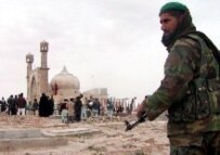 An ANA soldier stands guard as Muslims gather at a shrine in Herat (epa)