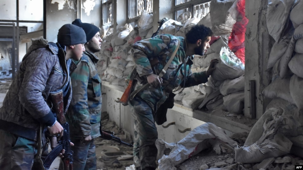 Syrian pro-government forces patrol an abandoned building in a newly retaken area of Aleppo's Old City on December 8.