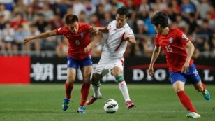 Iran's Masoud Shojaei (center) challenges South Korea's Lee Myoung-ju (left) and Kim Chang-soo during their World Cup qualifying soccer match in Ulsan.