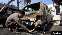 A Pakistani policeman looks for evidence after a deadly suicide attack in Shabqadar on March 7.
