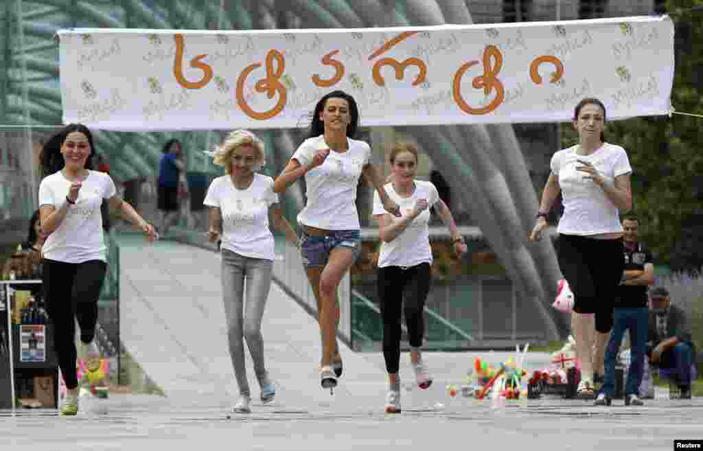 Contestants bear down on the finish line during a high heels race in Tbilisi on June 24. (Reuters/David Midzinarishvili)