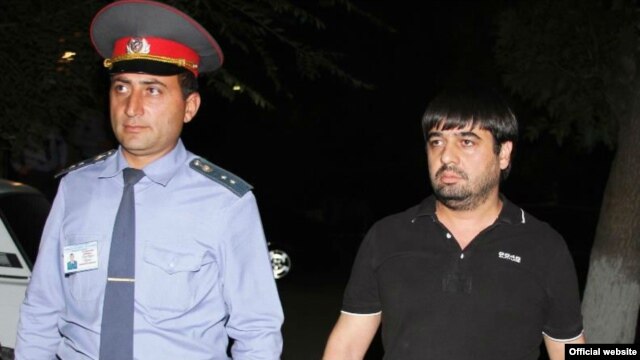 Armenia -- A policeman escorts Sevak Minasian, the arrested son of the deputy prosecutor of Armavir region, 26Sep2012.