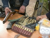 Kyrgyz police show weapons and leaflets allegedly belonging to Hizb ut-Tahrir members seized in March (RFE/RL)