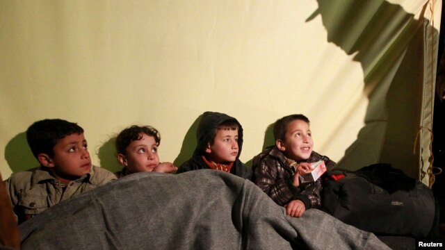 A soldier gives food and water to Syrian children after they crossed the border into Jordan in February.