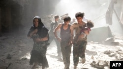 A Syrian woman and youths, one of them carrying a wounded baby, flee the site of a reported barrel-bomb attack by Syrian government forces in the northern city of Aleppo in June 2014.
