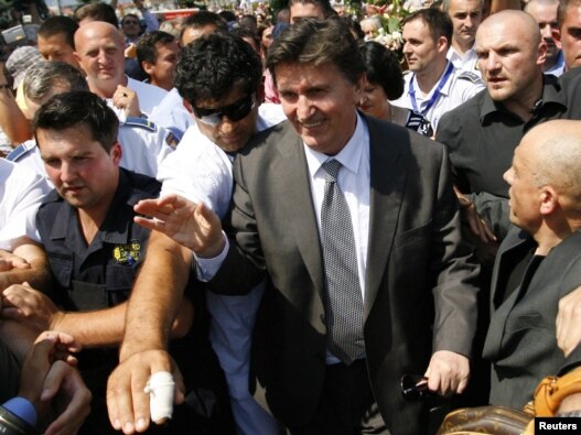 Former Bosnian wartime leader Ejup Ganic is greeted by a crowd as he arrives at Sarajevo airport on July 28.