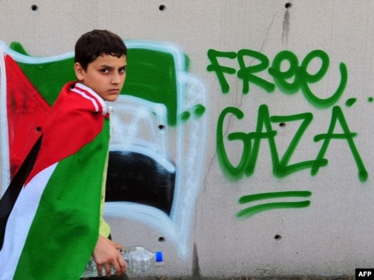 A boy wears a Palestinian flag during an anti-Israeli protest in front of the Israeli Consulate in Istanbul