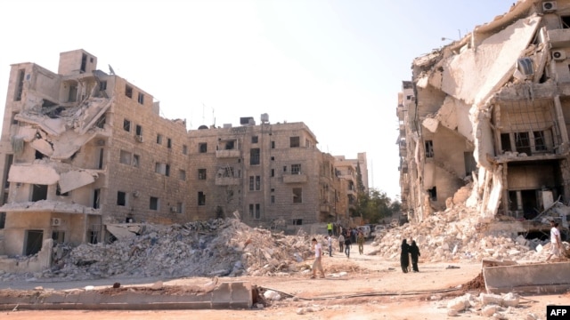 Syria -- People walk past a row of destroyed buildings near the Al-Hayat Hospital in the northern city of Aleppo, 10Sep2012