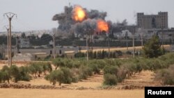 Smoke and flame rise after what fighters of the Syria Democratic Forces (SDF) said were U.S.-led air strikes on the mills of Manbij where Islamic State militants are positioned, in Aleppo Province, on June 16.