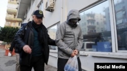 Турецкий полицейский ведет гражданина России, предположительно завербованного исламистами. Иллюстративное фото.