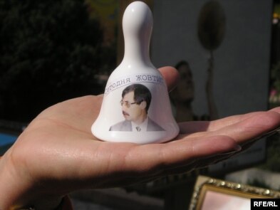 A Kazakh supporter of Yevgeny Zhovtis holds a bell that reads 