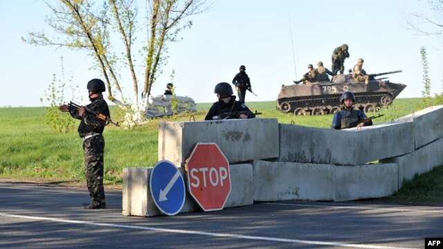 Ukrainian police and soldiers guard a checkpoint near the eastern city of Slovyansk on April 25. 