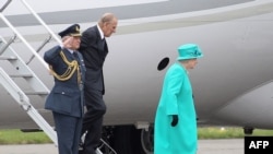 Britain's Queen Elizabeth II (wearing green) and Prince Philip, the Duke of Edinburgh (centre) arrive in Dublin.