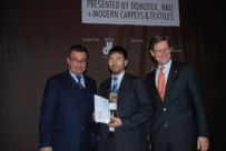 Hajji Nabbi (center) receives the Domotex prize in Hannover, Germany