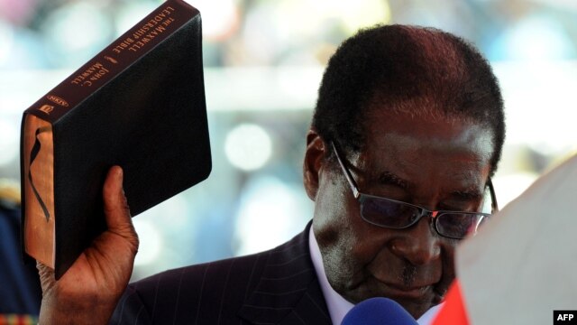 Президент Зимбабве Роберт Мугабе приводится к присяге с Библией в руках в ходе инаугурации в Хараре. 22.09.2013