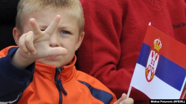 A child shows the traditional Serb three-finger salute in Pale, in Bosnia's Republika Srpska, on September 8. He's waving the Serbian flag.