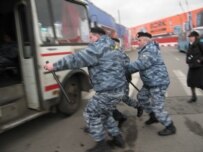 OMON officers escorting activists to a bus today (RFE/RL)