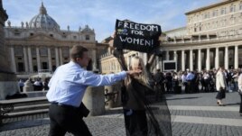 A Femen activist is stopped by security in front of St Peter's Basilica in Rome in November.