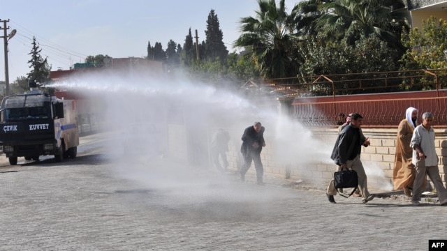 Turkish police fire water cannon to disperse Syrian nationals who crossed the border after Syrian aircraft bombed a strategic border town on November 12.