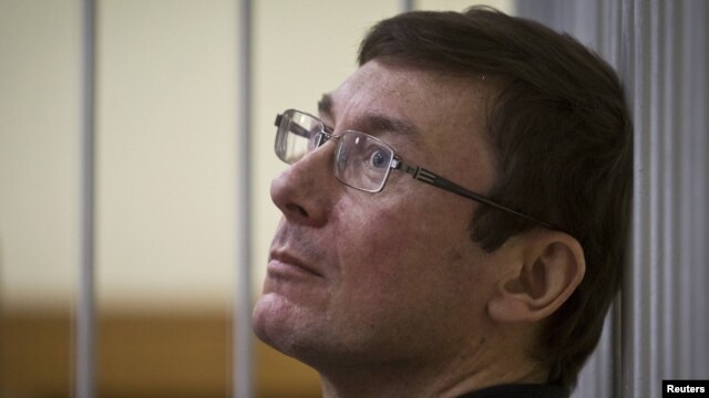 Former Interior Minister Yuriy Lutsenko looks on from the defendant's cage as he attends court session in Kyiv last year.
