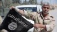 A Syrian government soldier displays an Islamic State (IS) group flag after Syrian troops regained control the previous day of Al-Qaryatain, a town in the province of Homs, earlier this month.
