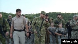 A screengrab from a video posted on Ramzan Kadyrov's VKontakte account of snap defensive drills and inspections that the Chechen strongman ordered, apparently with a view to illustrating the Caucasus republic's defensive readiness.It also shows Kadyrov (center) with a group of armed children dressed in fatigues.