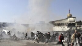 People react seconds after the suicide blast ripped through a Shi'ite gathering in Kabul on December 6.
