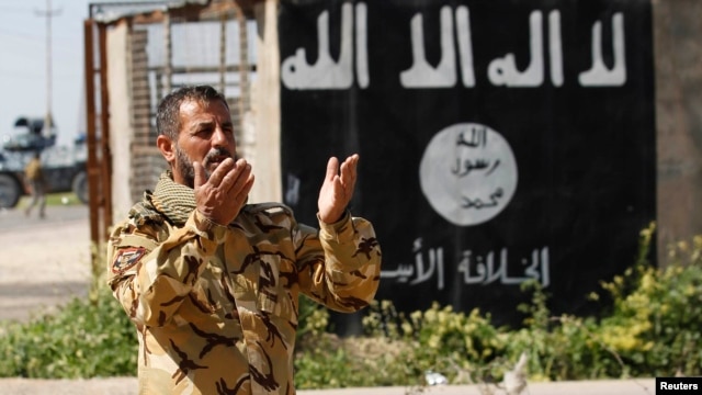 یکی از افراد گروه شیعی «بسیج مردمی» در عراق در منطقه‌ای که از داعش بازپس گرفته شده‌است