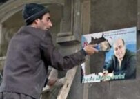 An Azeri man clears campaign posters in Baku after the elections (epa)
