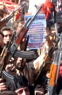 Iraqis hold their weapons during a protest against the attack on the holy Golden Mosque in Samarra today (epa)