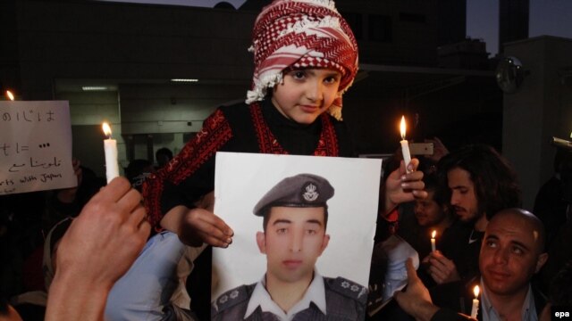A Jordanian girl holds a picture of Jordanian pilot Muath al-Kasasbeh during a prayer vigil in Amman on February 2.