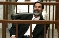 Saddam Hussein laughs while listening to testimony given by a defense witness (file photo) (epa)