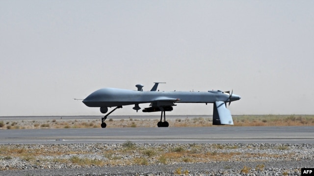 A U.S. Predator unmanned drone armed with a missile sits on the tarmac of Kandahar military airport. 