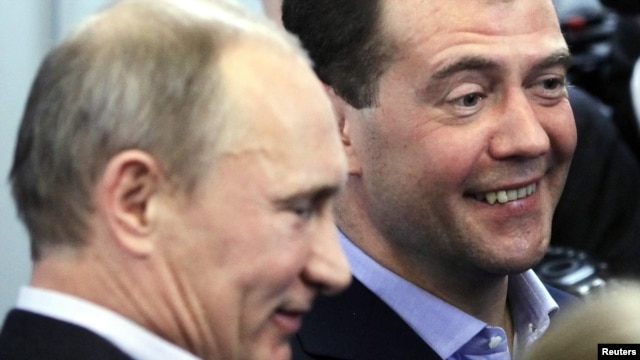 Prime Minister Vladimir Putin (left) and President Dmitry Medvedev try to smile as they visit the headquarters of the United Russia party after voting closed in Moscow on December 4.