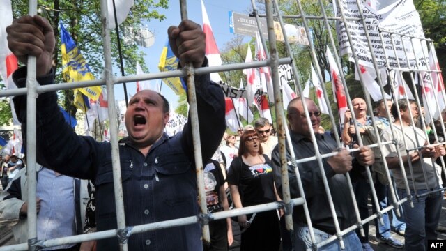 Сторонники экс-премьера Юлии Тимошенко требуют, чтобы президент Виктор Янукович "ответил, за что он пытает и убивает Тимошенко". Киев, 27 апреля 2012 года  