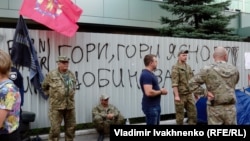 A metal fence covered with signs reading 'Burn, Inter, burn!' and 'Inter is a Kremlin agent!' erected after the fire remained in front of the TV offices on September 7.