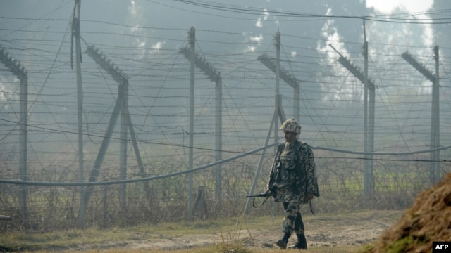 An Indian Border Security Force soldier patrols along the border fence at an outpost along the India-Pakistan border in Suchit-Garh on January 10.